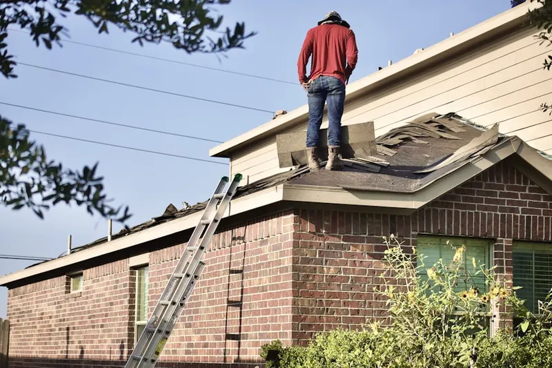 Professional roofer working on a residential roof in East Williston